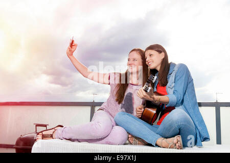 Due giovani donne che assumono autoritratto con smart phone, Monaco di Baviera, Germania Foto Stock