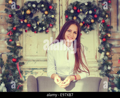 La felicità e il concetto di vacanze. Sorridente ragazza adolescente divertirsi sulla decorazione di Natale sfondo Foto Stock