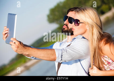 Coppia giovane facendo un ritratto con tavoletta digitale Foto Stock