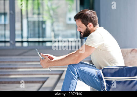 Maschio studente universitario con tavoletta digitale Foto Stock