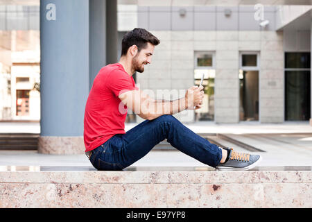 Maschio studente universitario con tavoletta digitale del campus Foto Stock