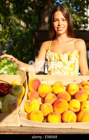 La donna per la vendita di frutta e verdura al mercato in stallo Foto Stock