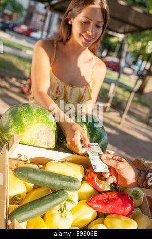 Donna acquistare verdure in stallo del mercato Foto Stock