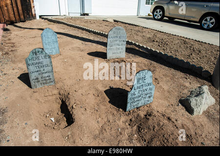 Rancho Bernardo in California, Stati Uniti d'America ottobre 21,2014 più di una settimana ad Halloween, alcuni prati anteriori e case nel quartiere benestante della parte settentrionale di San Diego sono decorate con elementi di spaventoso. È caldo e soleggiato qui, non buio e cupo, così è piuttosto divertente invece di spaventosi. Il segno "happy Halloween' in particolare è ridicolo. Foto Stock