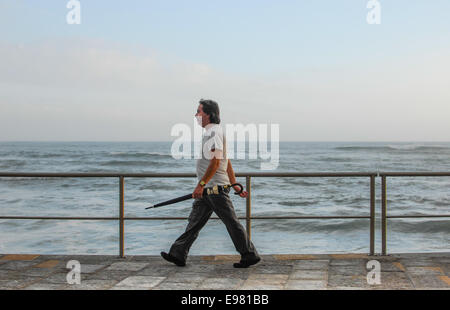 Uomo che cammina con ombrellone a Estoril Cascais Portogallo Foto Stock