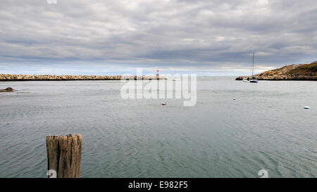 Vista sul Porto di Rockport affacciato su ampia distesa acqua per apertura in frangiflutti. Basso sopra appeso bianco grigio bluastro nuvole Foto Stock