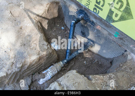 Poli cloruro di vinile (PVC) tubi essendo installati per la raccolta di acqua piovana sistema presso la casa nuova costruzione. Foto Stock