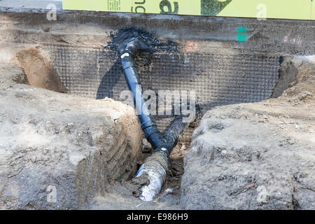 Poli cloruro di vinile (PVC) tubi essendo installati per la raccolta di acqua piovana sistema presso la casa nuova costruzione. Foto Stock
