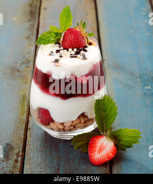 Sana dessert di fragole con yogurt cremoso stratificata con purÃ©e e frutta fresca in un bicchiere Foto Stock