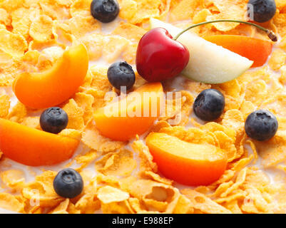 Frutta latte con cereali. Le pesche, mirtilli ciliegie e fette di mela nuotare nel latte Foto Stock