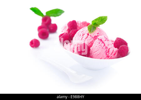 Il servizio della crema di lamponi surgelati gelato dessert con frutta fresca intera in porcellana bianca piatto su una riflessione sullo sfondo bianco Foto Stock