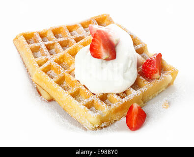 Fresche e mature rosso fragole e panna montata su una croccante cialda dorata cosparsa di zucchero per una rinfrescante dolce Foto Stock