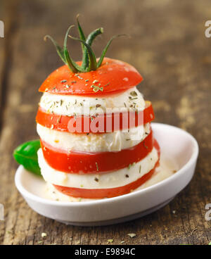 Torre di altenating fette di ripe rosso pomodoro e formaggio servita come un vegetariano acompaniment per un pasto Foto Stock