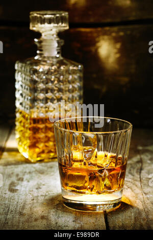 Vetro e bottiglia di liquore duro come scothc, bourbon whiskey o brandy su sfondo di legno con copyspace Foto Stock