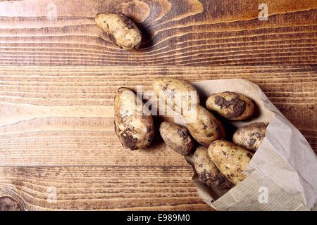 Appena raccolte mature patate naturale su di un tavolo di legno, alto angolo Foto Stock