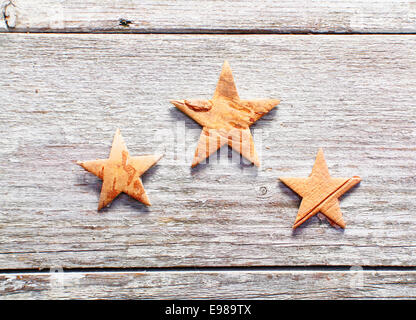 Decorativo tre stelle di natale su grungy alterate di tavole di legno con copyspace Foto Stock
