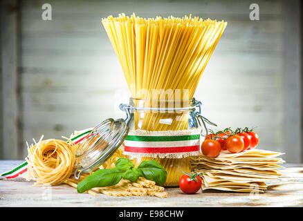 Bundle cruda essiccata spaghetti italiano legate con un nastro con i colori della bandiera nazionale - rosso, bianco e verde - con Foto Stock