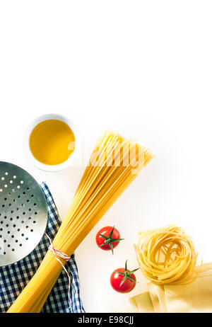 Preparare gli spaghetti italiani con una vista aerea del ingredienti crudi con un metallo sforzare cucchiaio, pomodori e olio di oliva su un blu e bianco a scacchi igienico isolato su bianco con copyspace Foto Stock