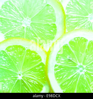 Sfondo colorato di fettine di succosa limes verde ricco di vitamina C con un sapore piccante usata come ingrediente e guarnire in cucina piena di overhead del frame vista ravvicinata Foto Stock