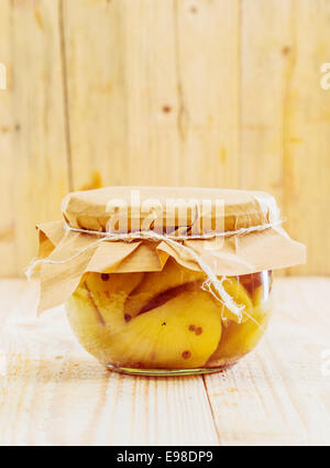 Specialità gourmet confezione di conserve di pere e vaniglia legato con un pezzo di rustico carta marrone e string in un di legno Foto Stock