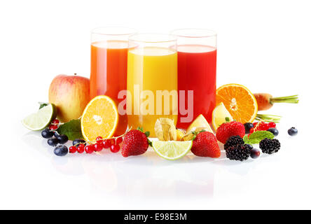 Disposizione colorati di frutta fresca comprese le bacche, gli agrumi e le mele con bicchieri di succo liquidised per un sano inizio di giornata Foto Stock