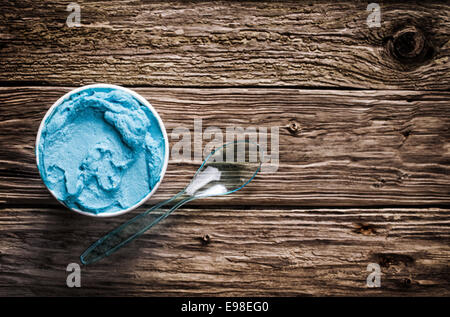 Cool blue rinfrescante gelato italiano in una vasca da asporto con un cucchiaio di plastica per un trattamento di benvenuto in una calda giornata estiva servita su Foto Stock