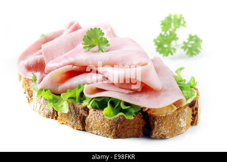 Deliziosi piatti gourmet sottile prosciutto fette su crostini di pane di segale con lattuga fresca e prezzemolo su sfondo bianco Foto Stock