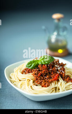 Italian spaghetti bolognese con un pomodoro delcious in base al sugo di carne su spaghetti noodles e rabboccato con parmigiano grattugiato e fresco Foto Stock