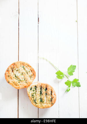 Grigliata di crosta croccante pane alle erbe su un bianco tavolo in legno con un rametto di prezzemolo fresco, vista aerea con copyspace Foto Stock