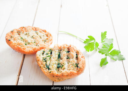 Deliziose grigliate di golden croccante pane alle erbe con prezzemolo fresco su un di legno bianco Tavolo da giardino e a basso angolo di visione Foto Stock