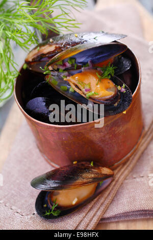 Al vapore marino gourmet le cozze in una pentola di rame condito con aneto fresco per un delizioso antipasto a base di pesce Foto Stock