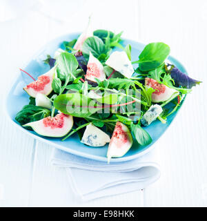 Pronto a mangiare i fichi e insalata selvatica sulla piastra quadrata, isolato su sfondo bianco. Foto Stock