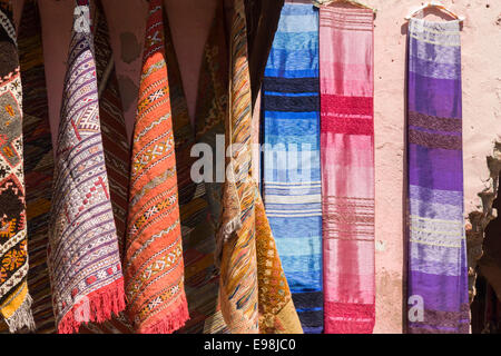 Tessuti appendere sul display al di fuori di un negozio nel souk, all'interno della medina di Marrakech (Marrakech), Marocco Foto Stock