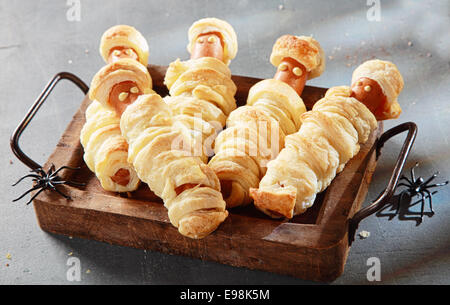 Cinque Weiner mummie avvolto in pasticceria sul vassoio per la festa di Halloween antipasti Foto Stock