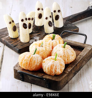 Un sano Halloween tratta fatto in Banana fantasmi e Clementine zucche arancione Foto Stock