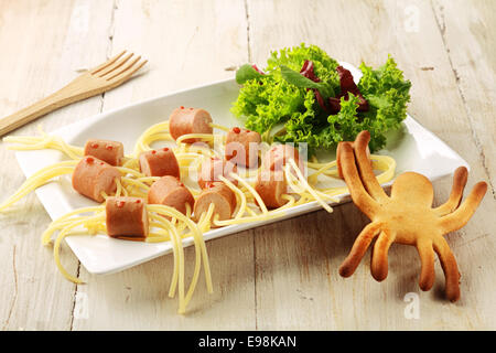 Wiener e Noodle Spider snack sulla piastra con decorazione su sfondo di legno Foto Stock