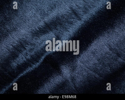 Sullo sfondo di un oscuro pezzo di morbida pelle scamosciata morbida pelle con rughe Foto Stock