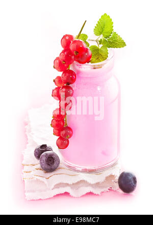 Un sano frullato di frutti di bosco in un vasetto di vetro con una deliziosa mature ribes rosso appesa sopra il lato Foto Stock