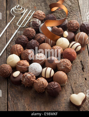 Il lusso cioccolato artigianale bonbon assortimento di deliziosi piatti decorativi cioccolatini rotondi con un festoso nastro per una celebrazione Foto Stock