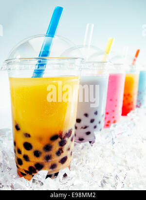 Fruttato assortiti di Boba Tea cocktail in una fila sul ghiaccio tritato Foto Stock