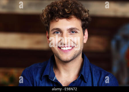Ritratto di un sorridente uomo bello con capelli ricci Foto Stock