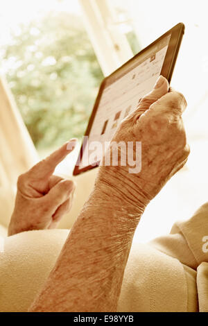 Senior persona mani usando un computer tablet. Foto Stock