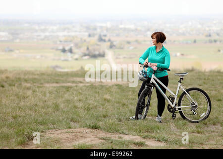 Un ciclista femminile mettendo in pausa per una pausa Foto Stock