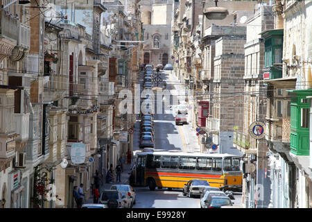 Un bus tenta di passare attraverso le strette lacune su Triq il-Vitoria, sulla penisola Seglea a La Valletta, Malta Foto Stock