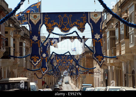 Banner infilate attraverso una strada per contrassegnare un festival locale a Paola, Malta Foto Stock