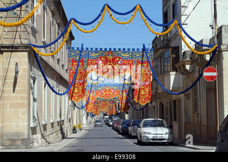 Banner infilate attraverso una strada per contrassegnare un festival locale a Malta Foto Stock