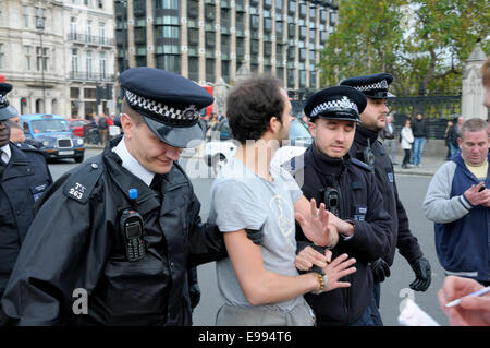 Londra, Regno Unito. 22 ottobre, 2014. Occupare Londra protestor rimane sul plinto di Winston Churchill statua in piazza del Parlamento - la polizia arresta un uomo per il lancio di cibo per lui. Foto Stock