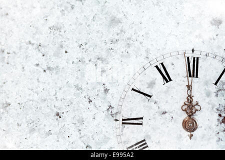 Capodanno a mezzanotte - vecchio orologio con stelle di fiocchi di neve e luci delle vacanze Foto Stock