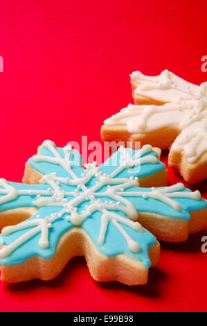 Close up decorate splendidamente il simbolo del fiocco di neve, ghiaccio, biscotti di Natale su una targhetta rossa con studio di illuminazione. Foto Stock