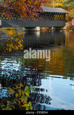 Vista panoramica di coperta in legno ponte sopra il lago colorato riflettente Foglie di autunno a Stone Mountain Park vicino ad Atlanta, Georgia. Foto Stock